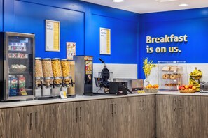 A breakfast station with various food options, including cereal, milk, and a waffle maker. - Days Inn & Suites by Wyndham Summerside (Summerside)