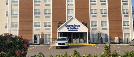 Un bâtiment Days Inn & Suites avec un parking situé devant.