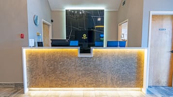 A reception desk with a modern design, a chandelier, and a sign that reads "SLUMBER."