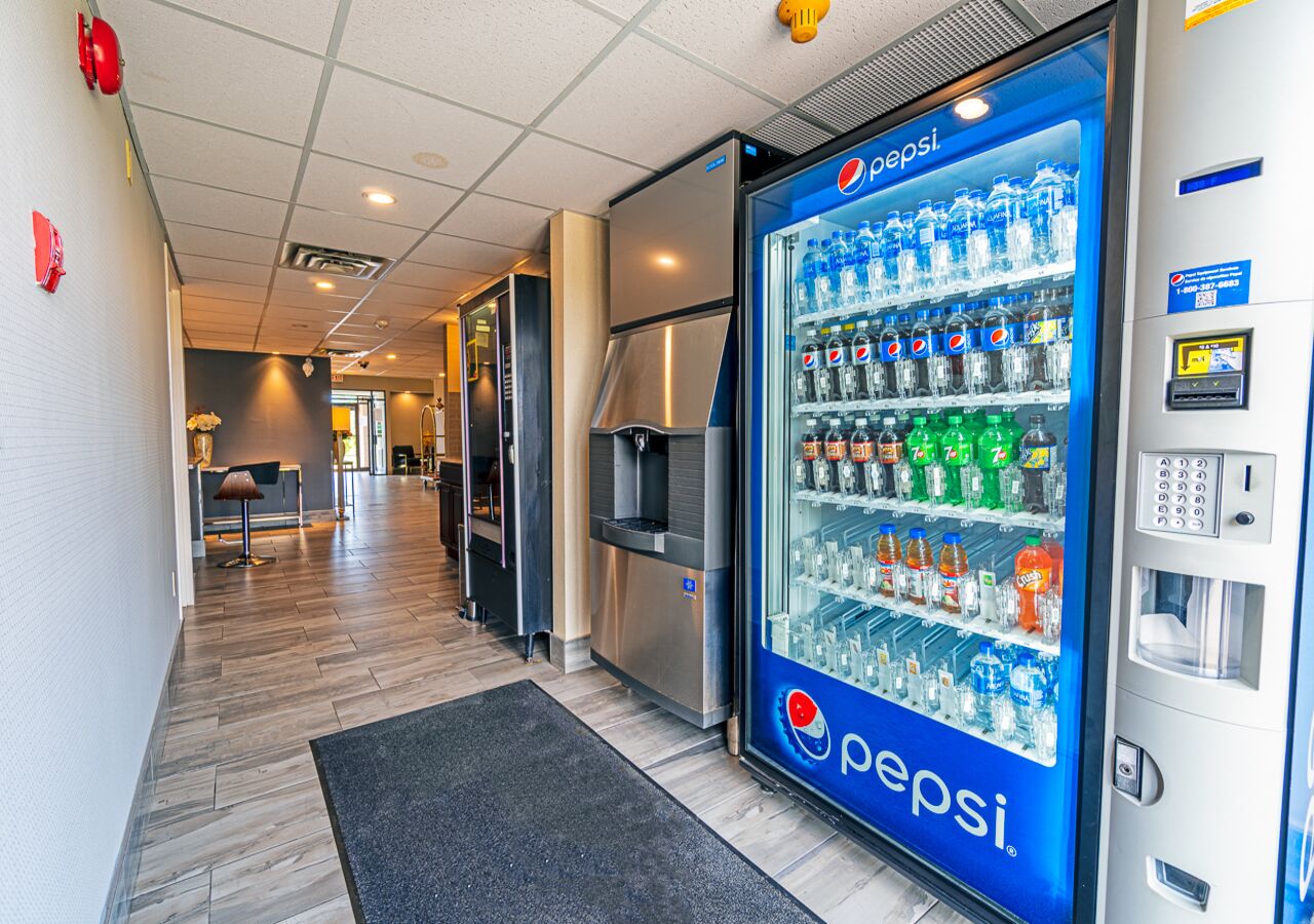 A hallway with a Pepsi vending machine, a microwave, and a water dispenser.