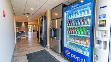 A hallway with a Pepsi vending machine, a microwave, and a water dispenser.