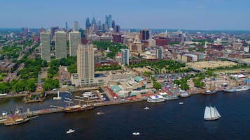 A waterfront cityscape with a mix of historic and modern buildings, a marina with boats, and a clear view of the skyline.