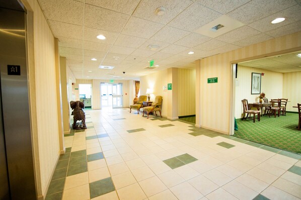En hotellobby med en incheckningsdisk, ett område med sittplatser och en matplats.
