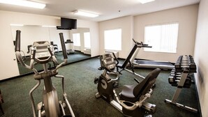 A gym with cardio machines, weightlifting equipment, and a treadmill.