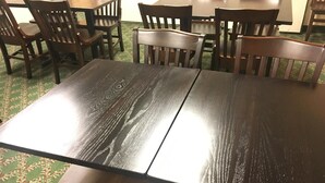 A dining area with a large wooden table and several chairs.