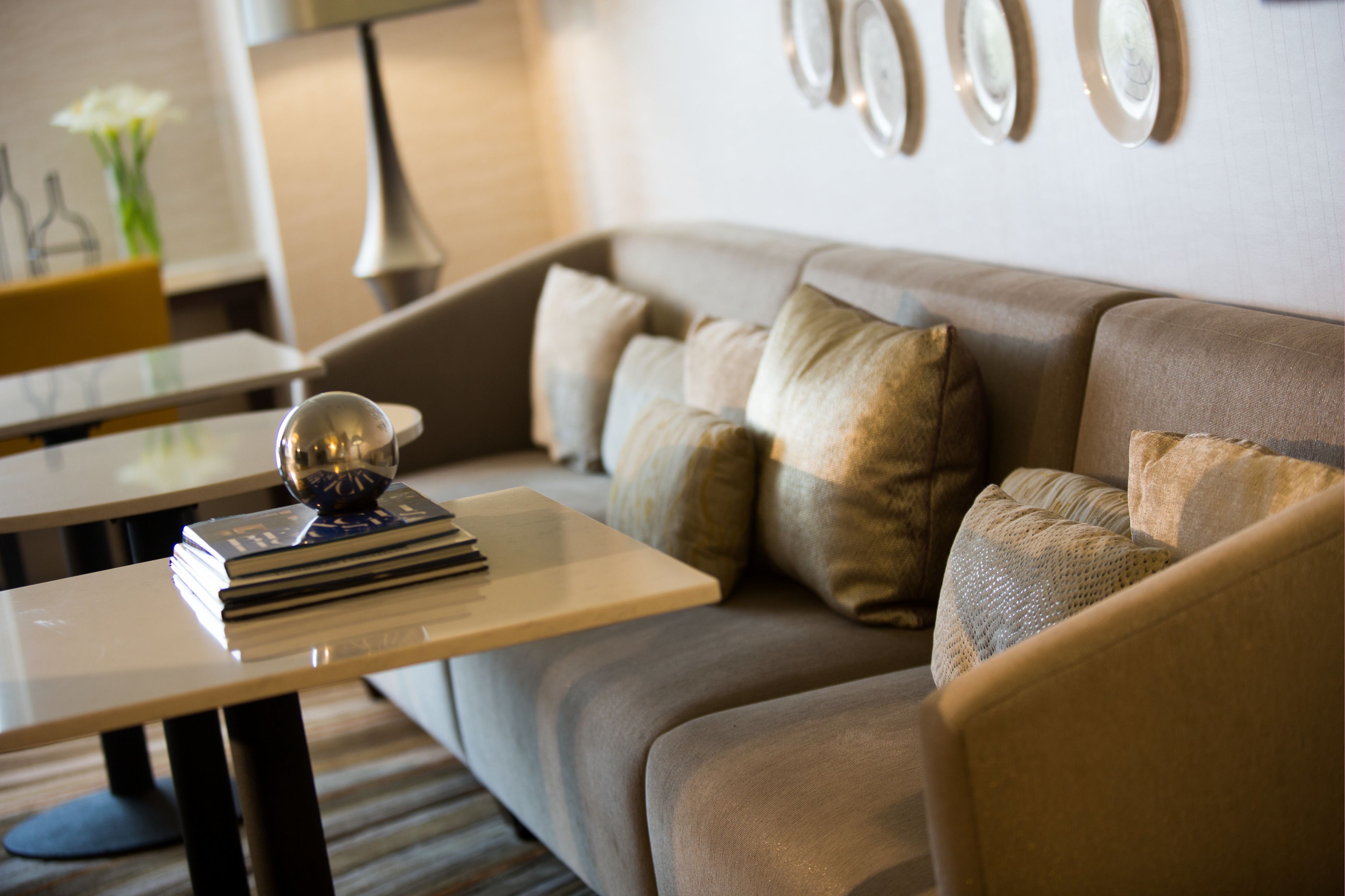 A modern living room with a sofa, a coffee table, and a lamp.