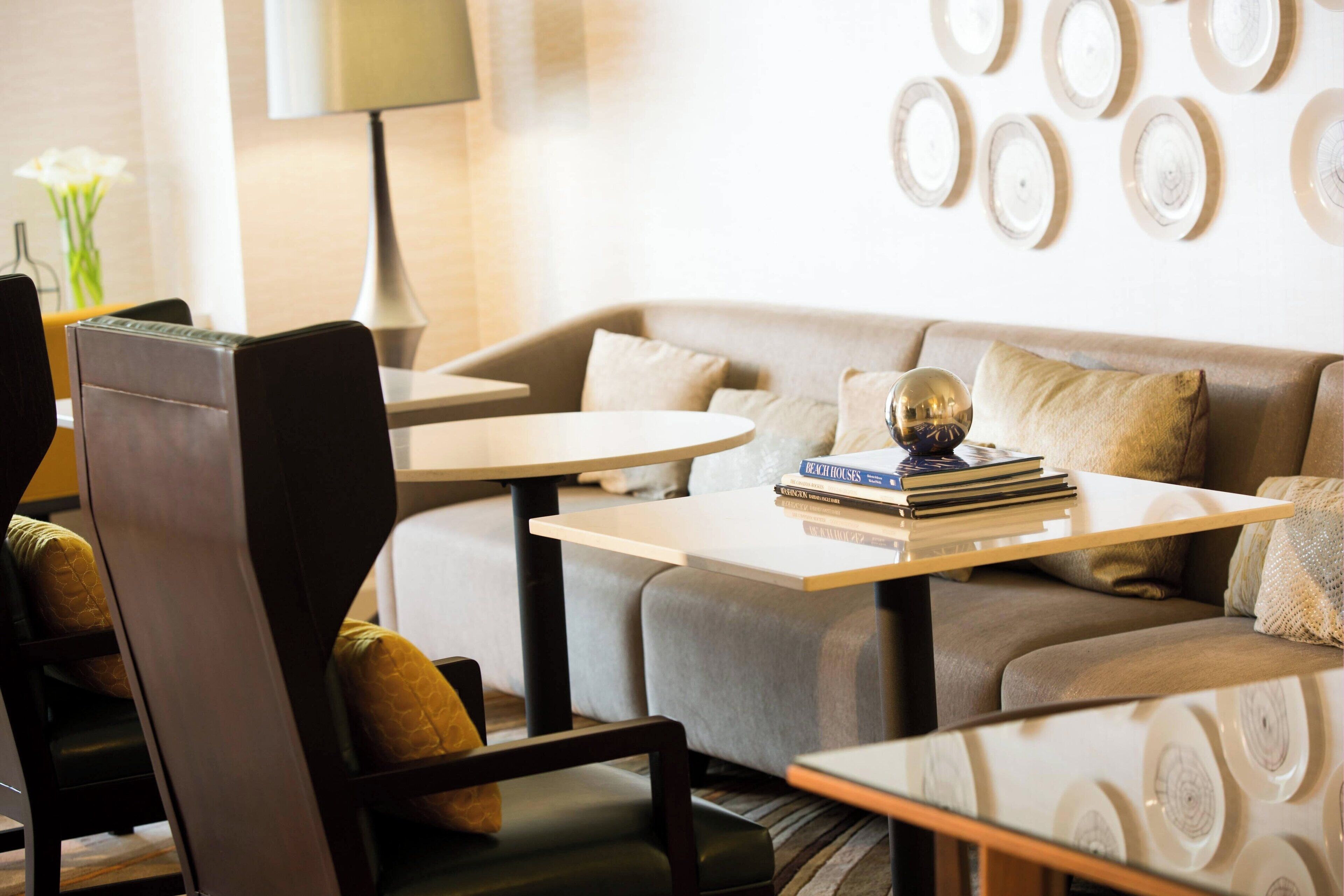 A modern living room with a sofa, armchairs, a coffee table, and a lamp.