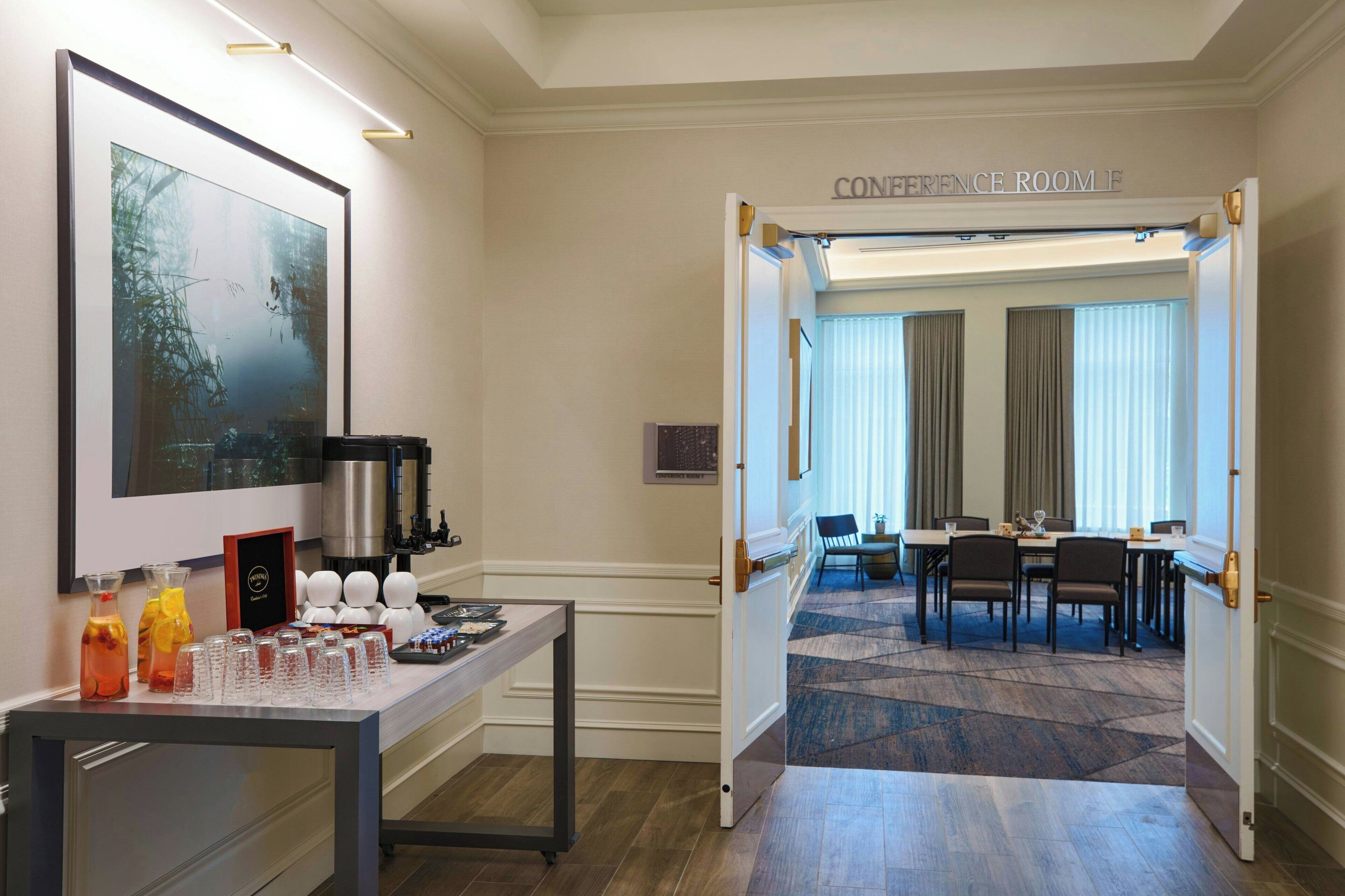 A conference room with a table, chairs, and a coffee station.