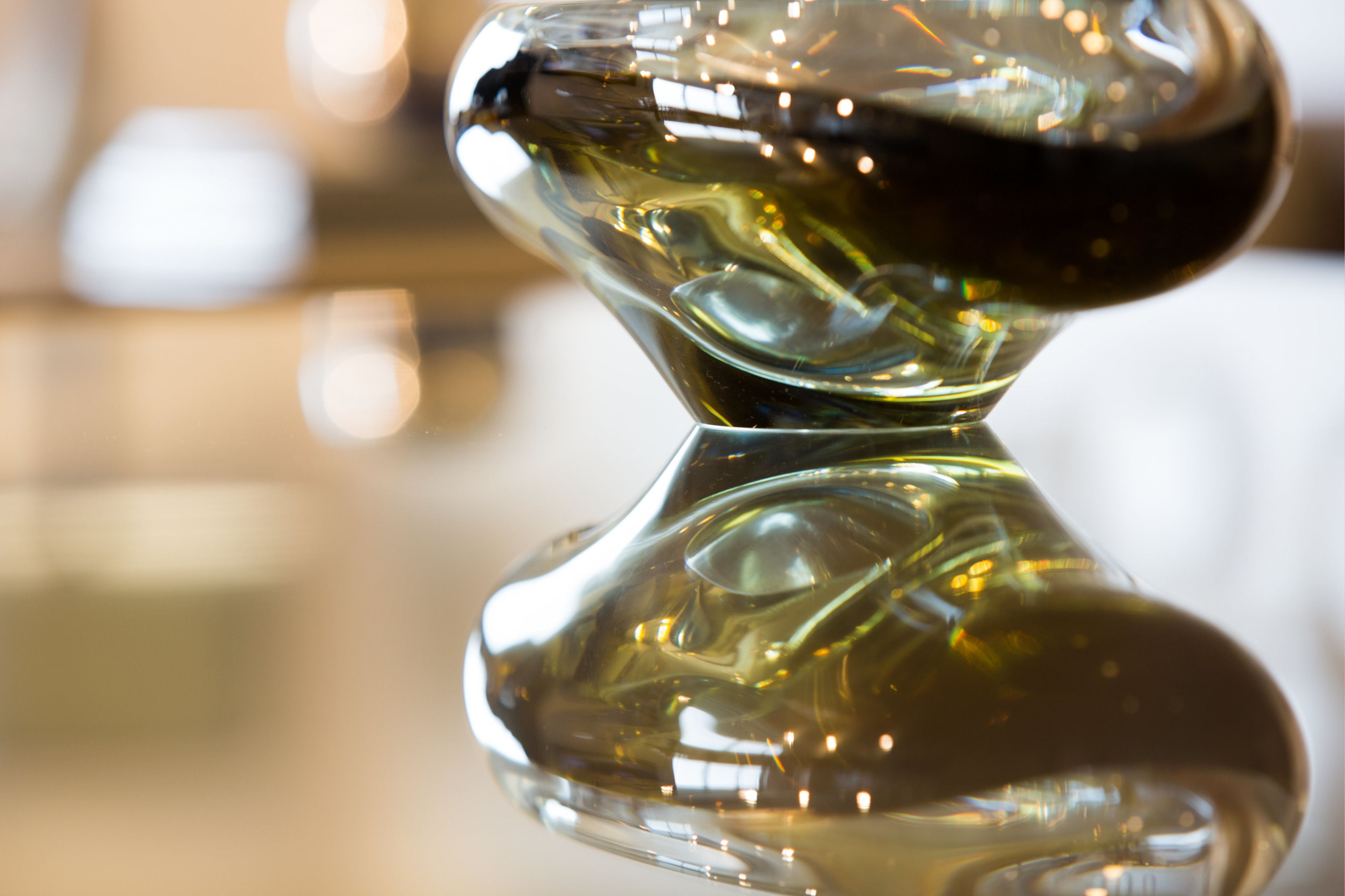 A close-up of a clear glass object with a reflective surface.