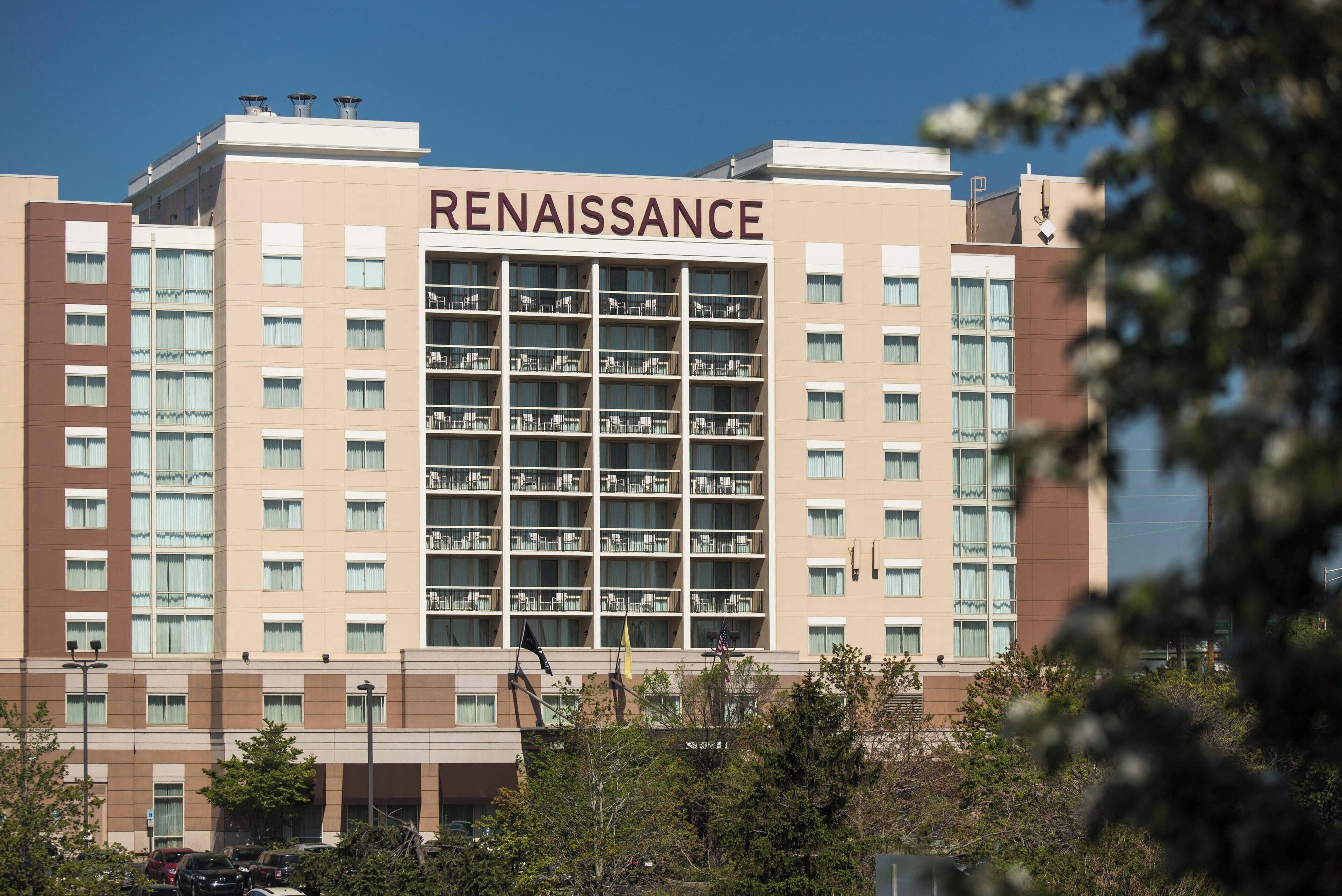 A multi-story hotel named 'Renaissance' with a modern architectural design, featuring balconies and a central atrium.