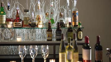 A bar area with various bottles and glasses, including whiskey, wine, and beer.