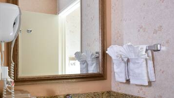 A bathroom with a granite countertop, a sink, a mirror, and a towel rack.