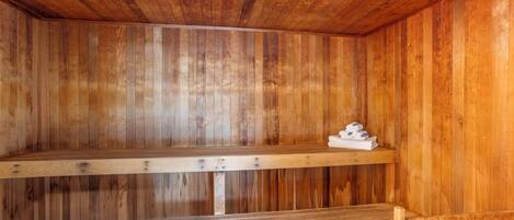 A wooden sauna with benches and a shelf.
