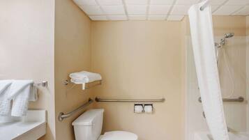 Une salle de bain équipée de toilettes, d’une douche et d’un porte-serviettes.