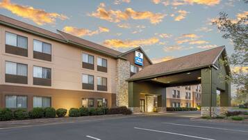A hotel with a stone facade, a Best Western sign, and a covered entrance.