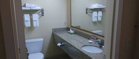Un baño pequeño y limpio con inodoro, lavabo y toallero.