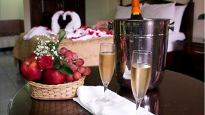 Ein Tisch mit einem Korb voller roter Äpfel, einem Glas Champagner und einer Champagnerflasche.