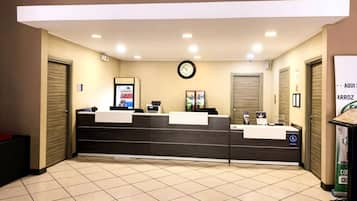 A reception area with a reception desk, a clock, and a trash bin.