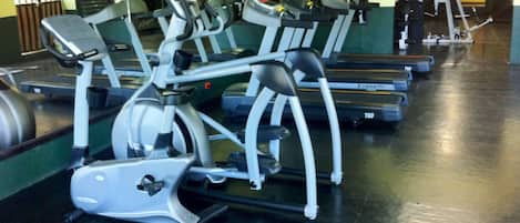 Un gimnasio con múltiples cintas de correr y máquinas elípticas.