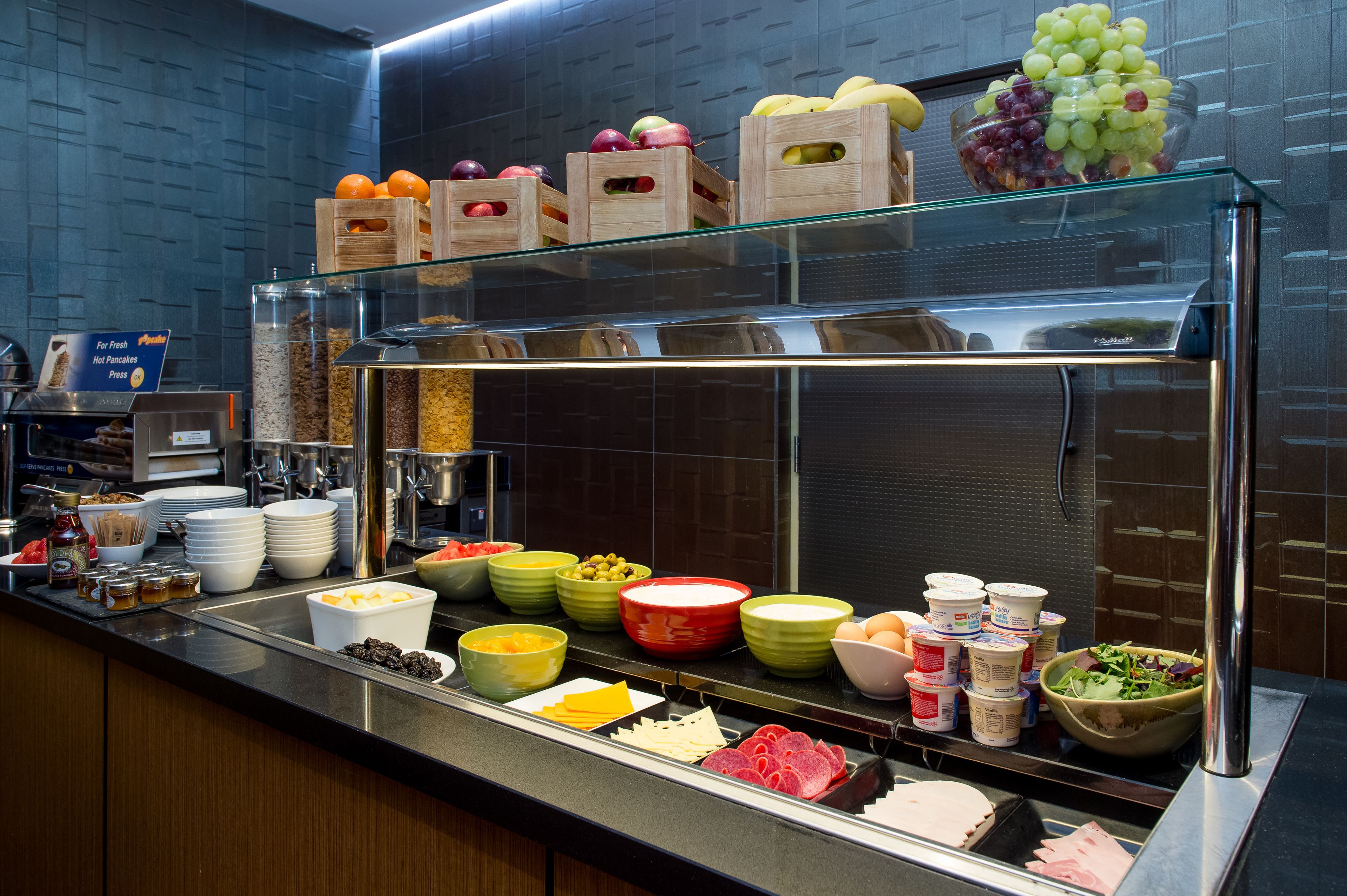 Un buffet proposant une variété de plats, notamment des fruits, des fromages et des viandes.