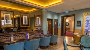 A hotel lobby with a bar area, seating, and a reception desk. - Doubletree by Hilton London Marble Arch (London)