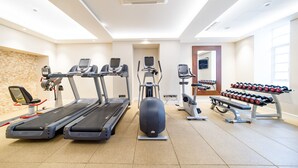 A gym with treadmills, an elliptical, a stationary bike, and a bench press. - Doubletree by Hilton London Marble Arch (London)