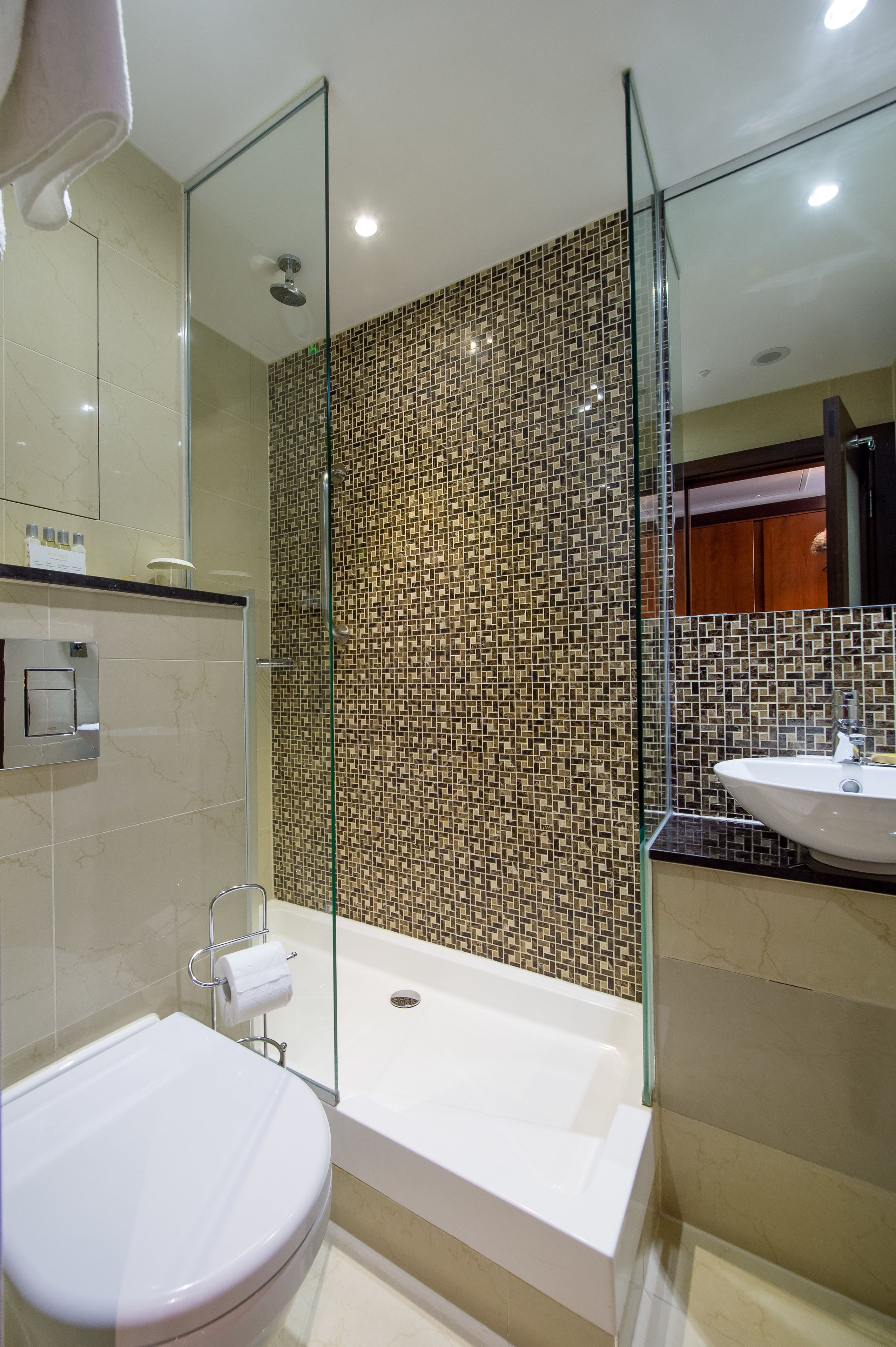 Une salle de bain moderne avec une douche à parois de verre, une baignoire blanche et des toilettes blanches.