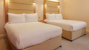 Une chambre d’hôtel avec deux lits, chacun doté d’une tête de lit et de lampes de chevet.