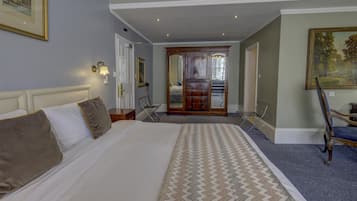 Habitación de hotel con una cama grande, un escritorio, una silla y un cuadro en la pared.