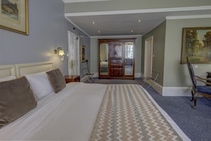 A hotel room with a large bed, a desk, a chair, and a painting on the wall. - Best Western Swiss Cottage Hotel (London)