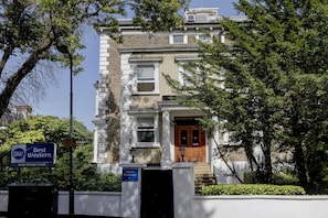 A traditional building with a prominent entrance, a sign for the Best Western Swiss Cottage Hotel, and a clear sky. - Best Western Swiss Cottage Hotel (London)