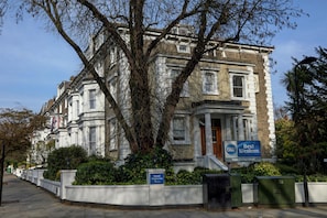 A traditional building with a large tree in front, a sign for Best Western Swiss Cottage Hotel, and a clear sky. - Best Western Swiss Cottage Hotel (London)