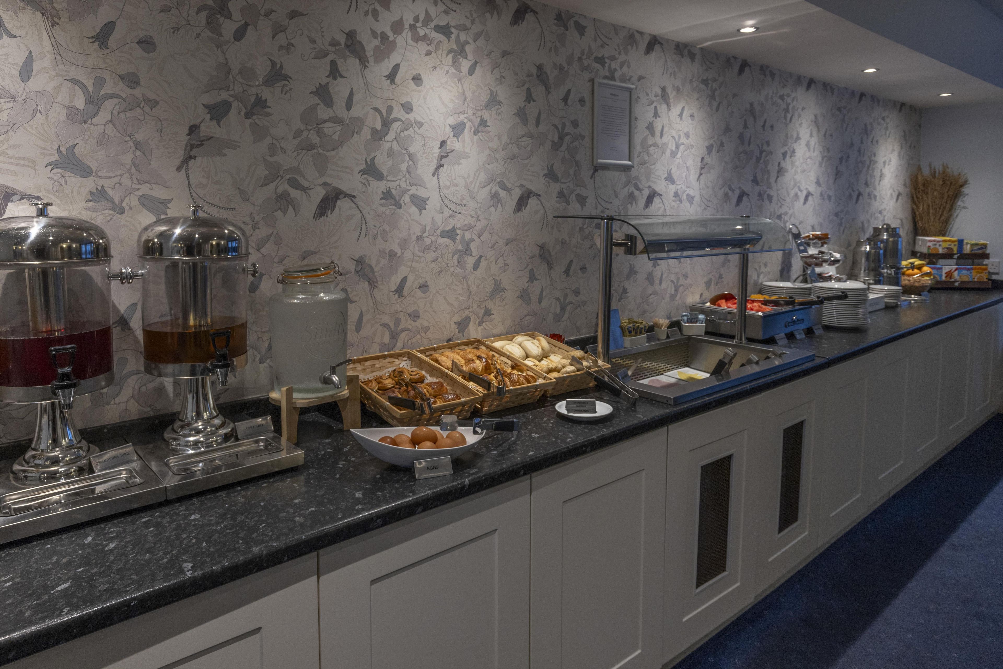 A buffet setup with various food items and beverage dispensers.