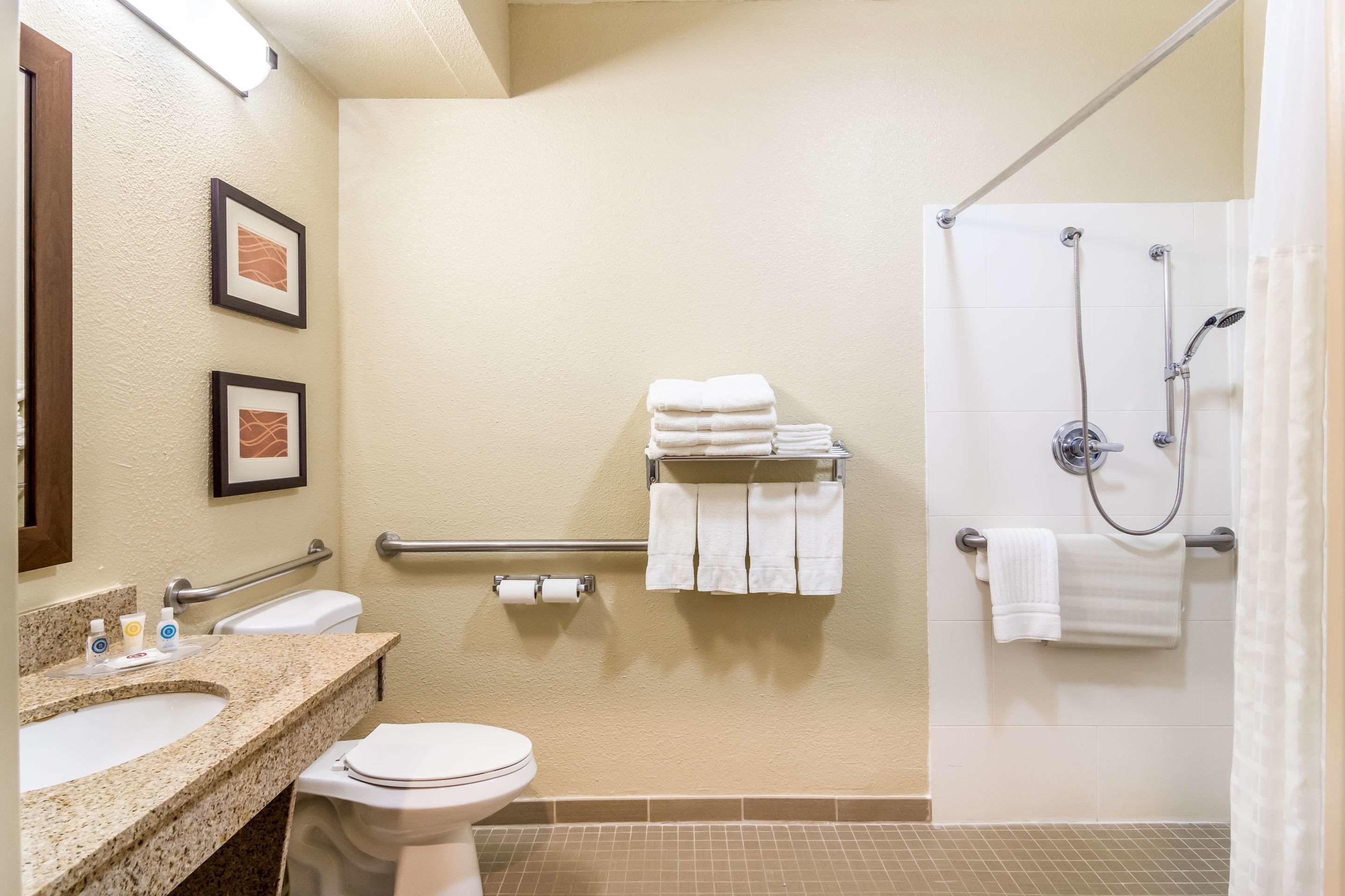 Ein Badezimmer mit Waschbecken, Toilette, Handtuchhalter und Dusche.