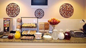 A kitchen counter with various food items and a television above it. - Comfort Inn Birmingham - Irondale (Birmingham)