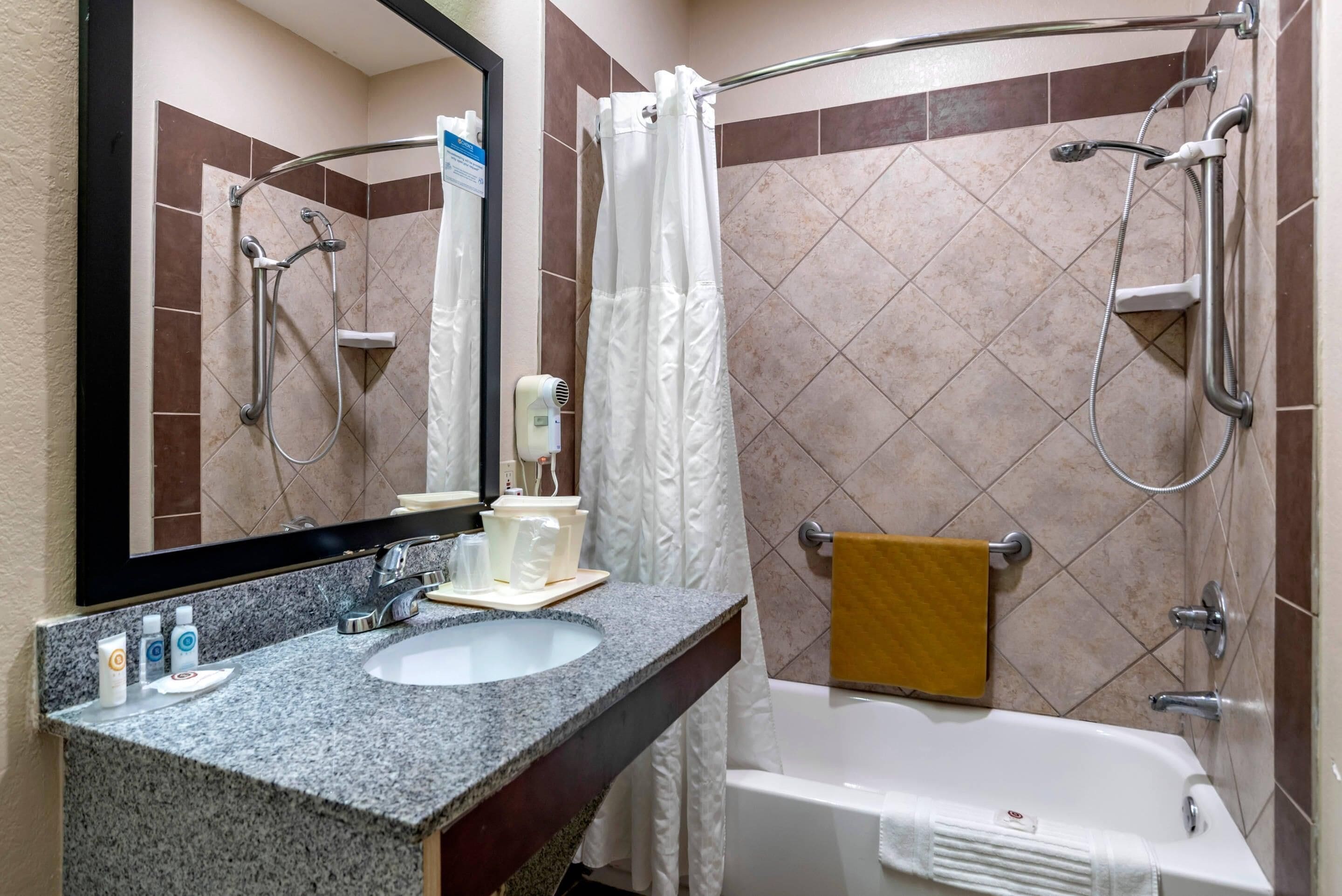 Une salle de bain équipée d’un lavabo, d’un miroir, d’une douche et d’une baignoire.