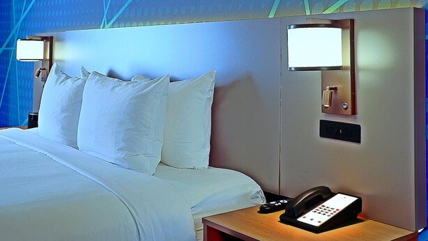 A hotel room with a bed, bedside lamps, a phone, and a wall-mounted control panel. - Comfort Inn & Suites Sierra Vista Near Ft Huachuca (Sierra Vista)