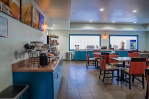 A restaurant with a counter, chairs, tables, and a view through large windows. - Comfort Inn & Suites Sierra Vista Near Ft Huachuca (Sierra Vista)