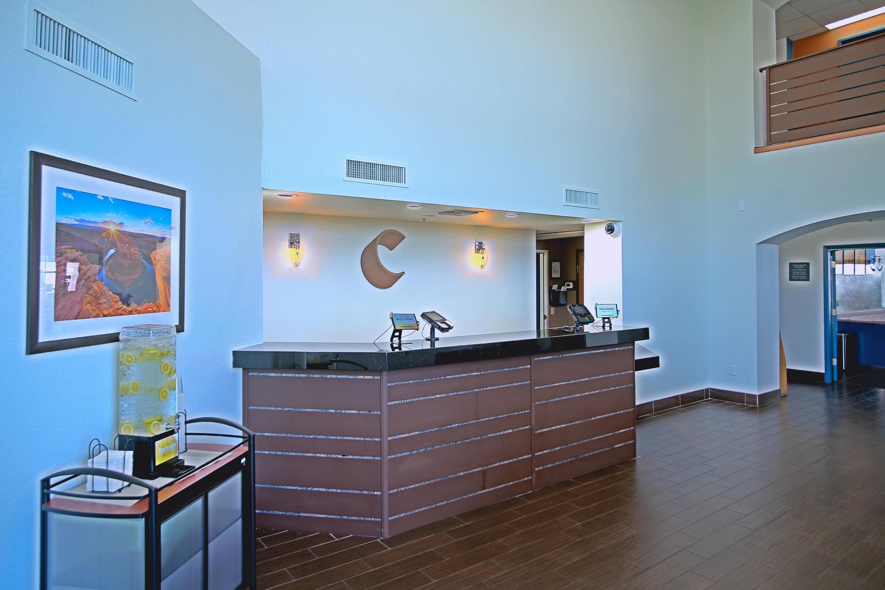 A reception desk with a counter, a wall-mounted picture frame, and a wall-mounted light fixture.