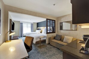 A hotel room with a bed, a sofa, a desk, and a mirror. - Holiday Inn Express & Suites Carpinteria by IHG (Carpinteria)