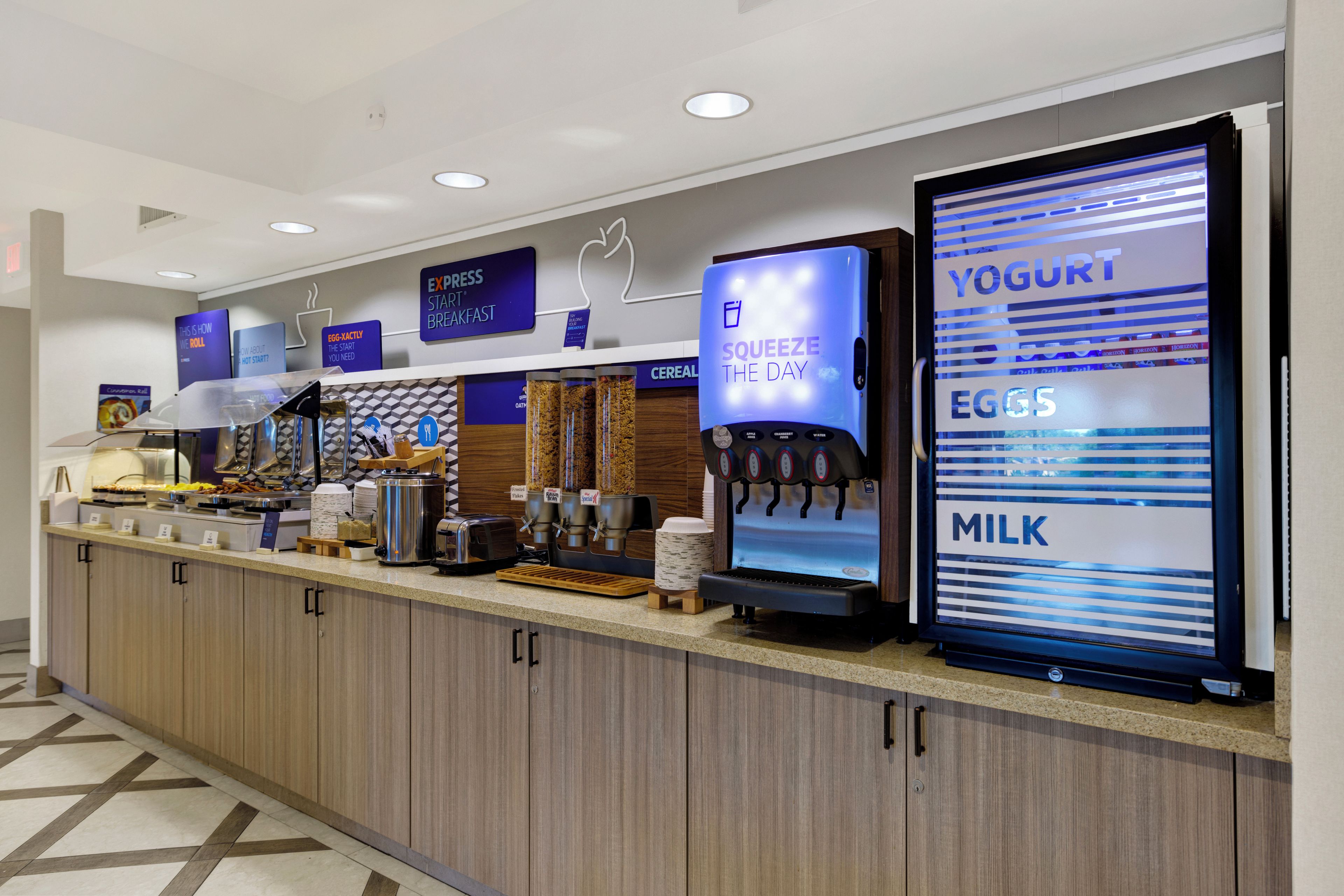 Una barra de desayuno con dispensador de yogur, máquina de café y dispensador de cereales.