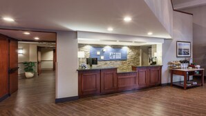 A reception area with a stone wall, wooden reception desk, and a framed picture on the wall.