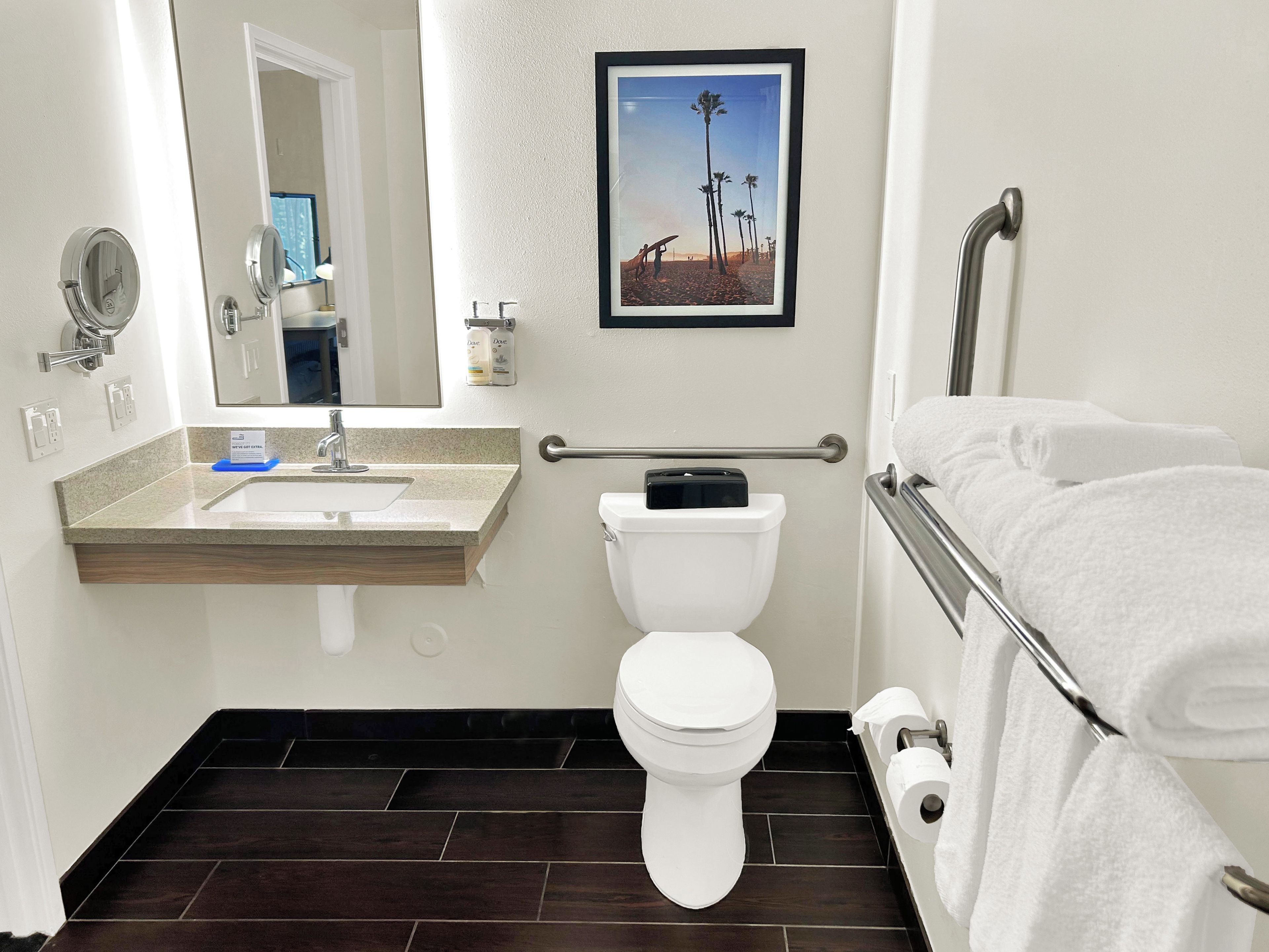 A bathroom with a toilet, sink, and towel rack.