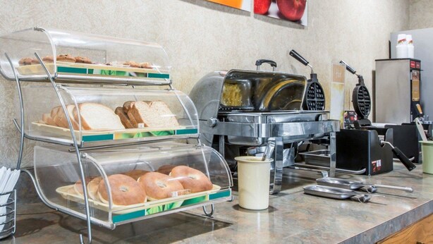 A breakfast station with bread, bagels, waffles, and a coffee machine. - Quality Suites San Diego Otay Mesa (San Diego)