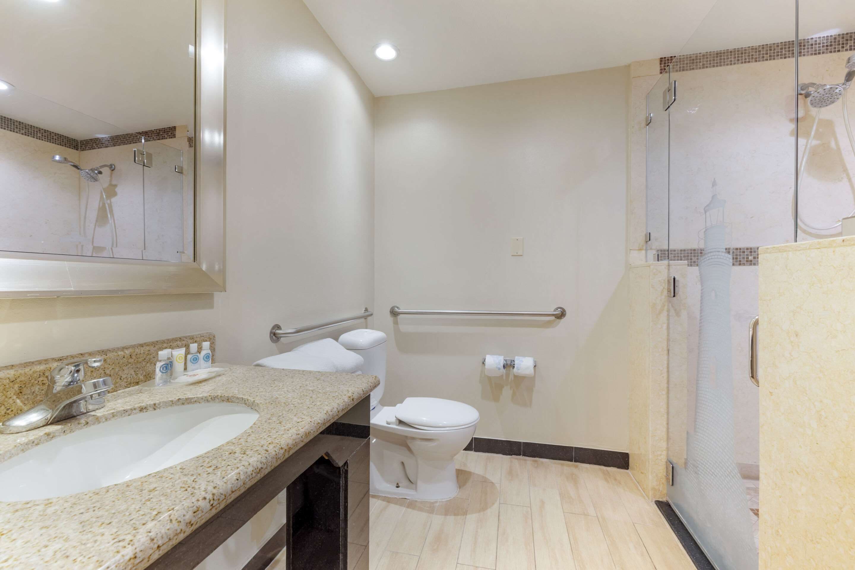 A bathroom with a sink, toilet, and shower area.