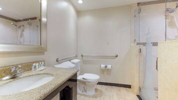 A bathroom with a sink, toilet, and shower area.