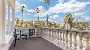 A balcony with a white balustrade, two black chairs, and a table. - Comfort Suites Oceanside Camp Pendleton Area (Oceanside)