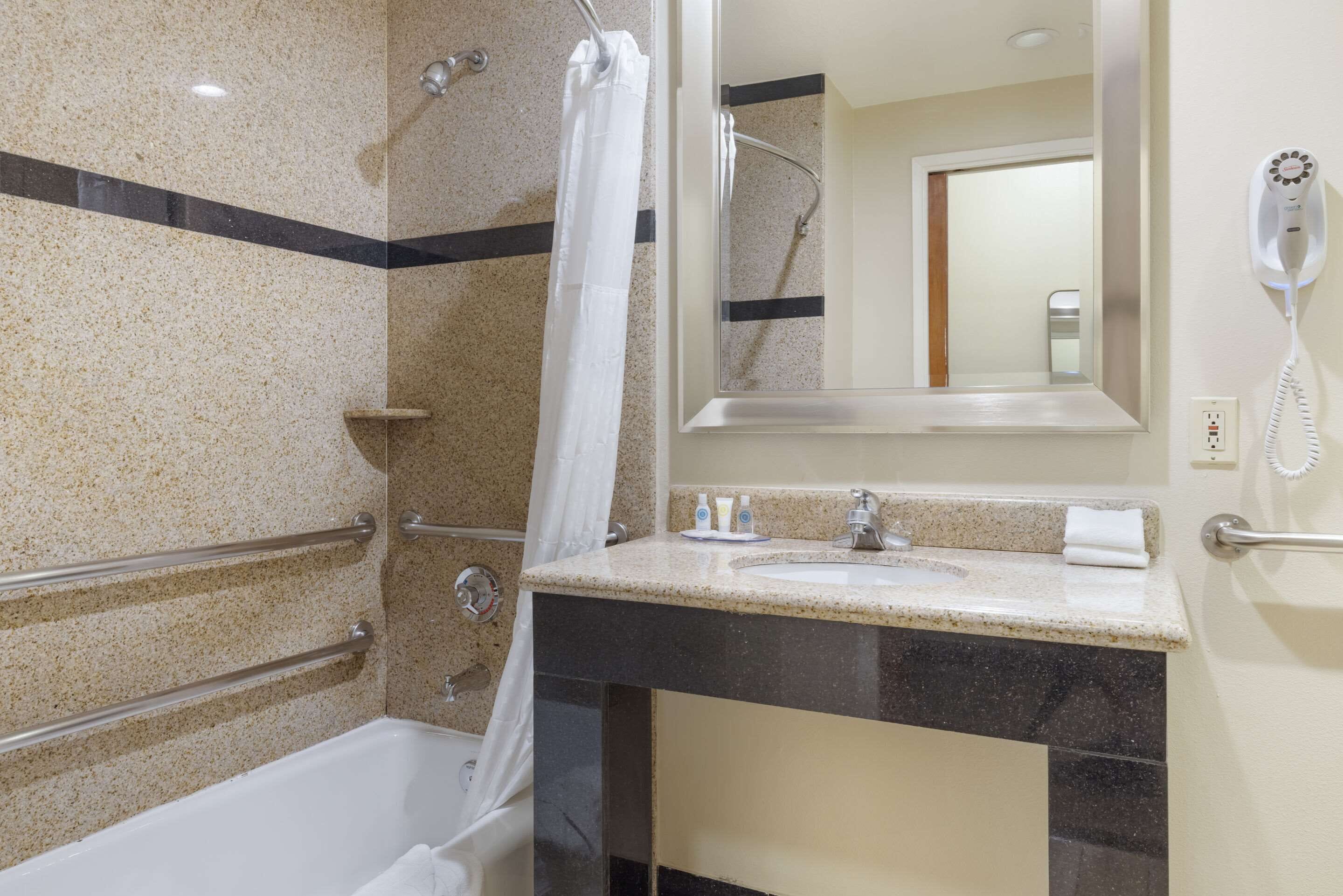 A bathroom with a bathtub, shower, and sink.