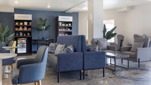 A modern lounge area with seating, a coffee table, and two 'Marketplace' signs indicating a food and beverage area. - Comfort Suites Oceanside Camp Pendleton Area (Oceanside)