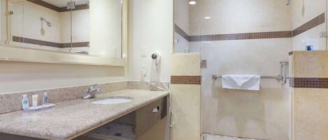 A bathroom with two sinks, a mirror, a shower, and a towel rack.